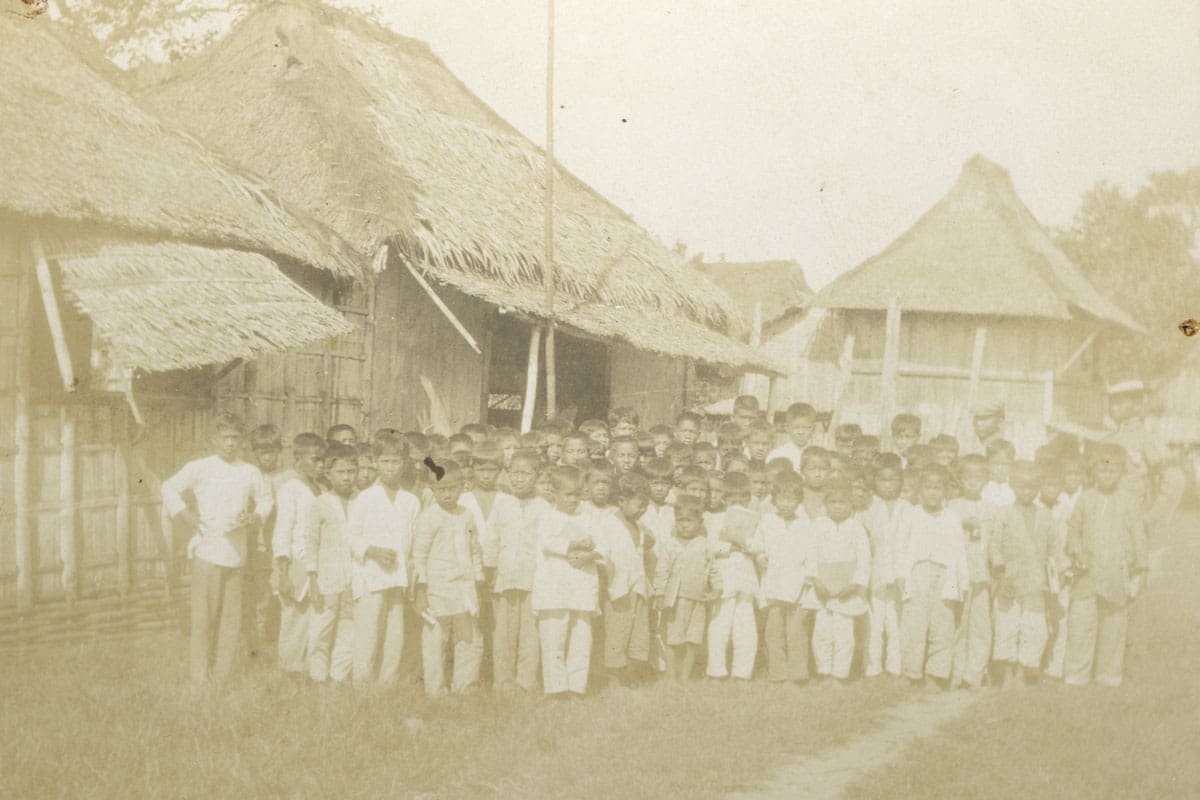 A group of school-age boys standing outside in the early twentieth century Philippines.