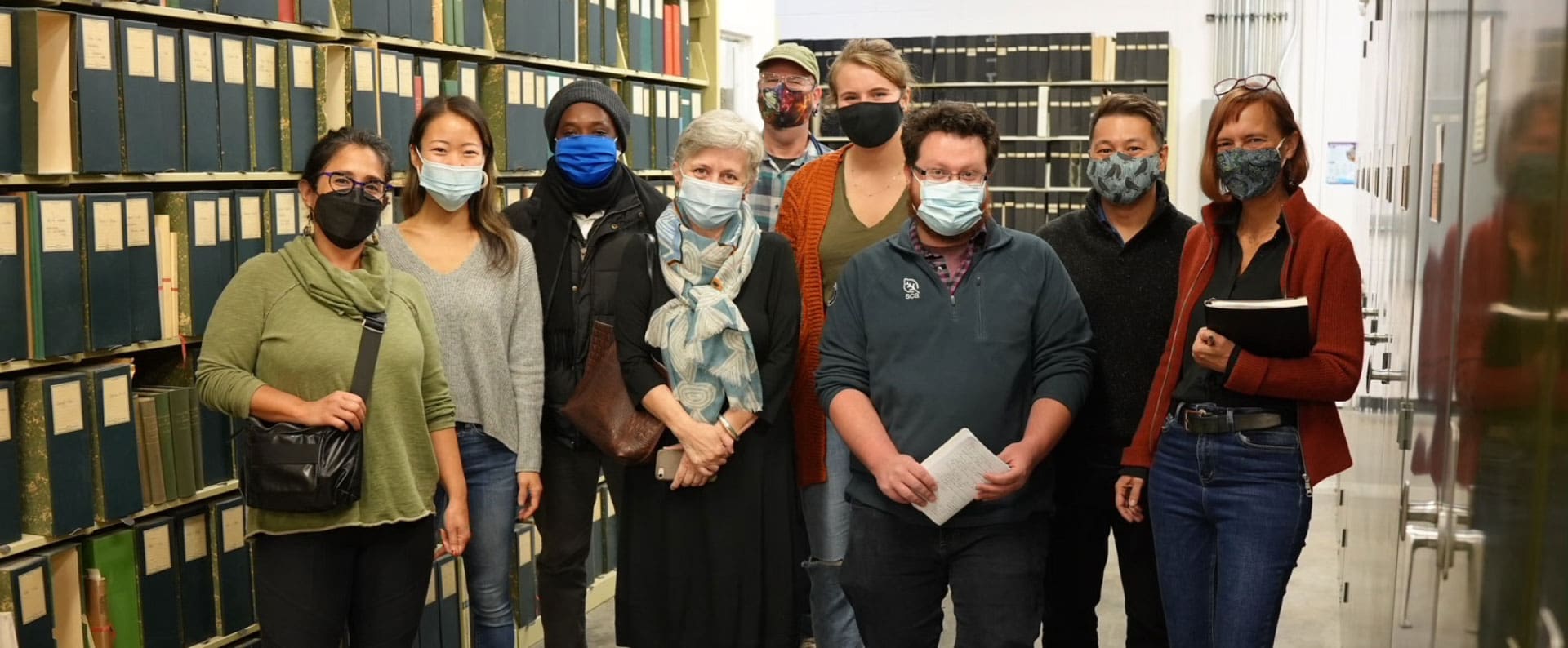 Nine masked members of the R/R team pose for a photo in the University of Michigan's Research Museums Center