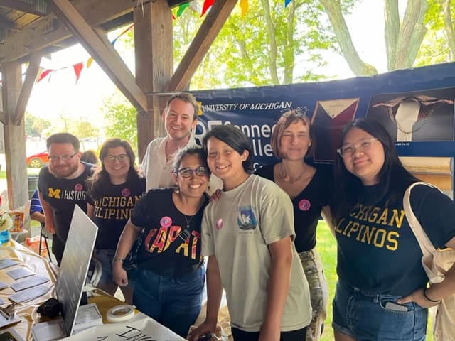 A group of people at an information table at a festival.