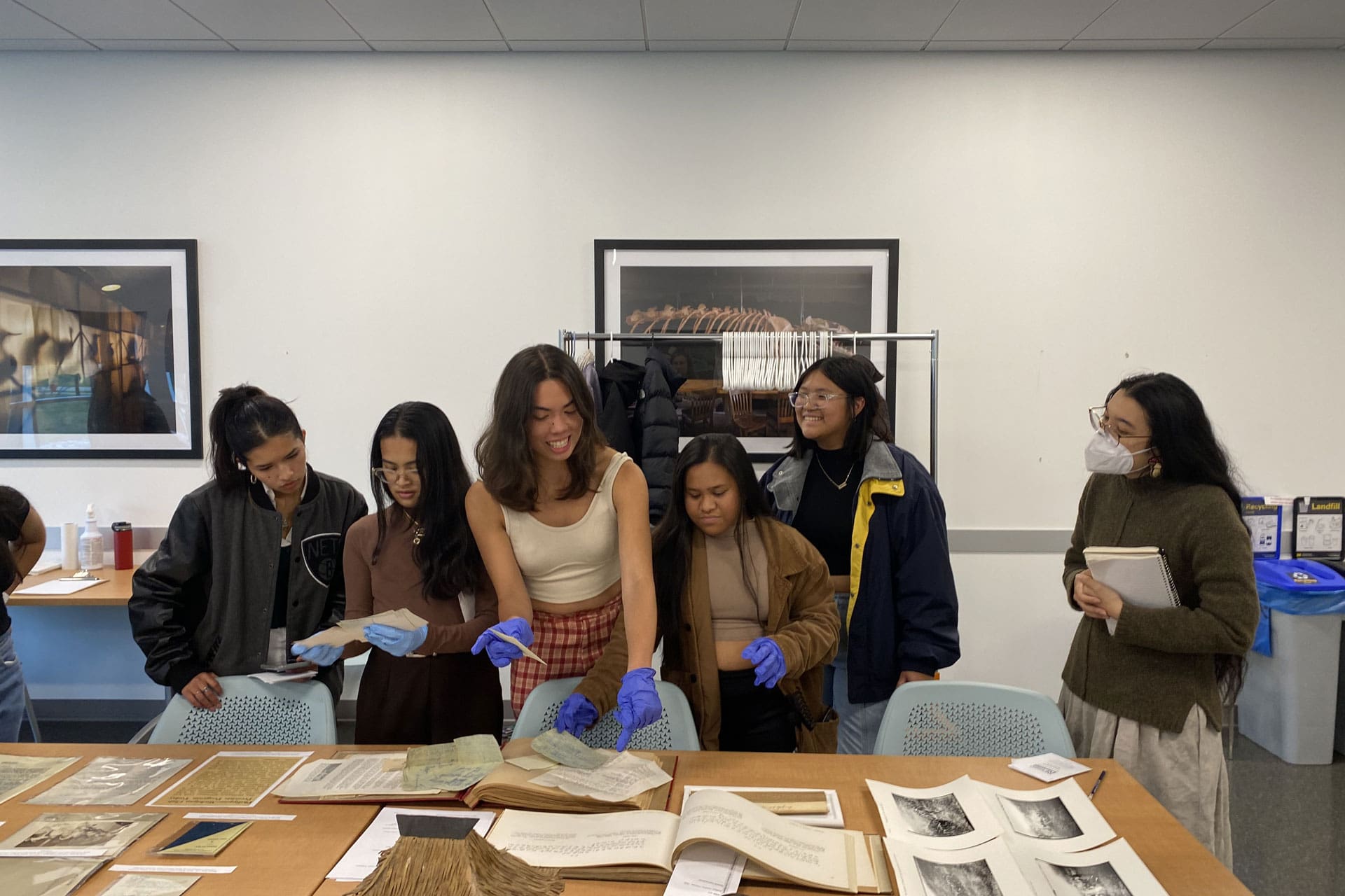 A group of students looking at various archival materials.