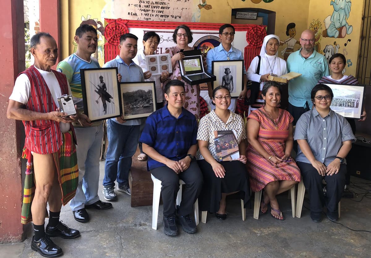 A group of people holding photographs.