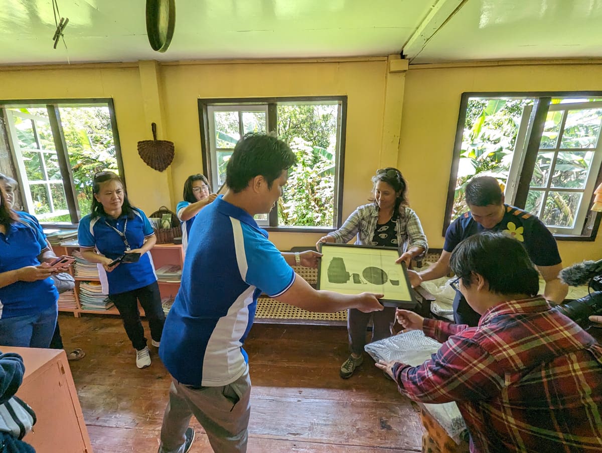 A group of people handing over photographs to another group.