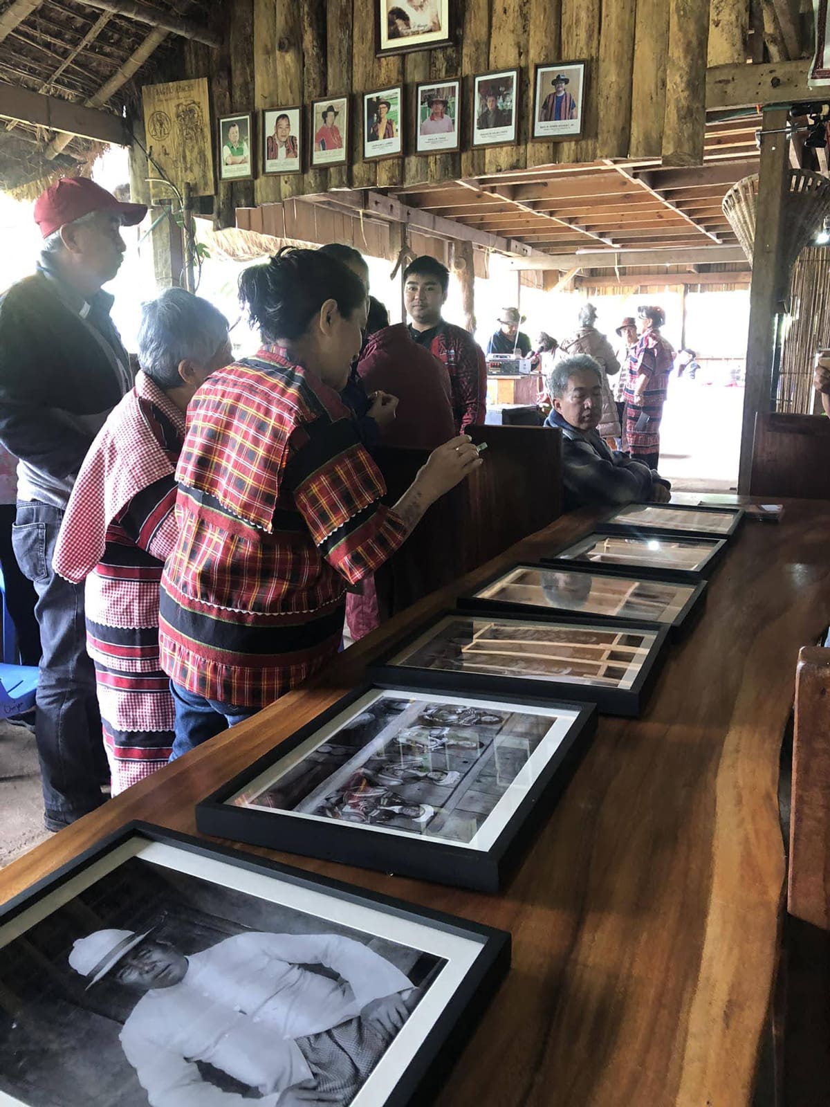 People looking at photographs on a table.