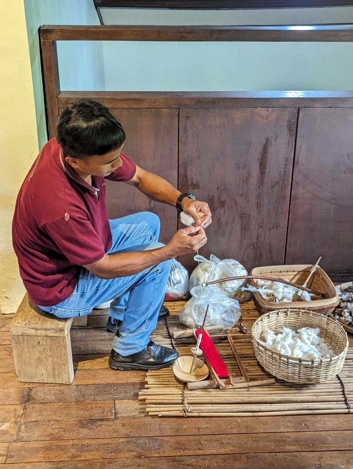 A man demontrating spinning cotton
