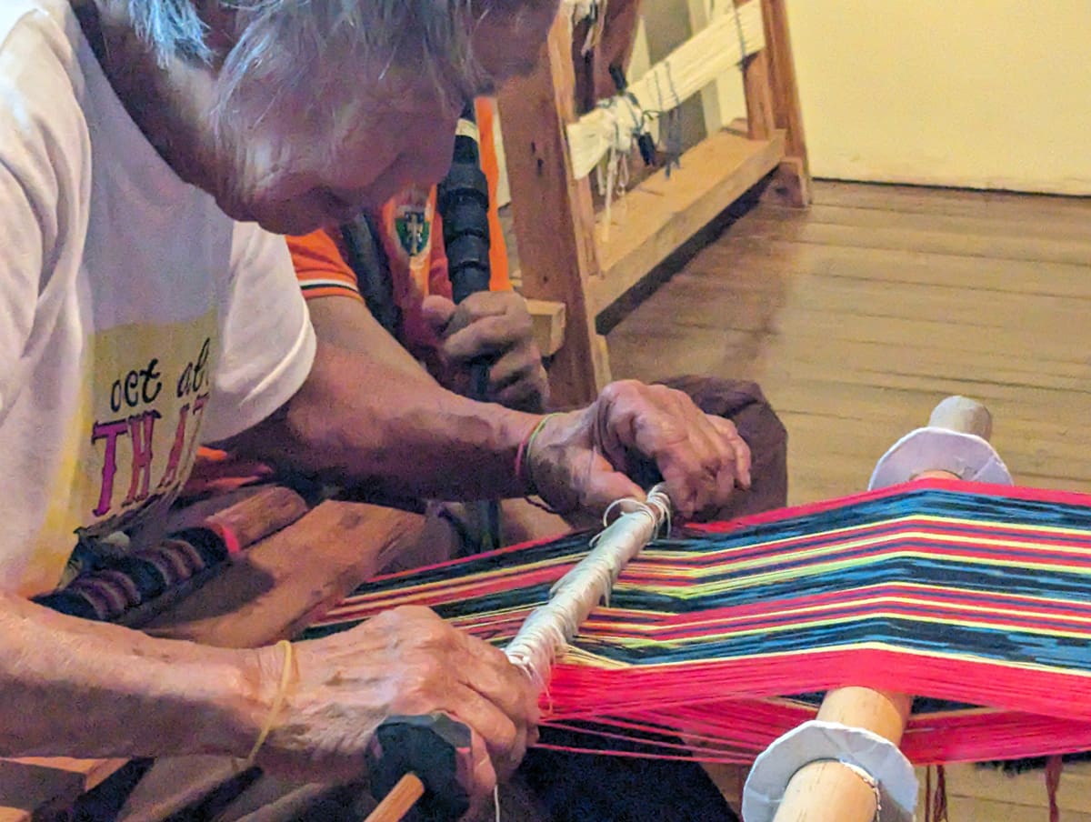 A woman demonstrating weaving.