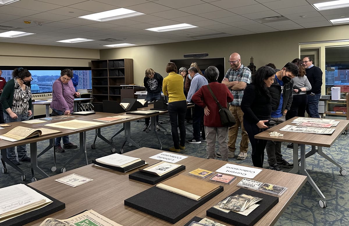 A small crown of people looking at materials at a library