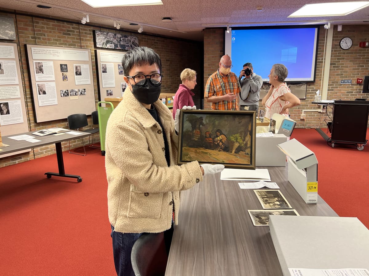 A person holding a painting.